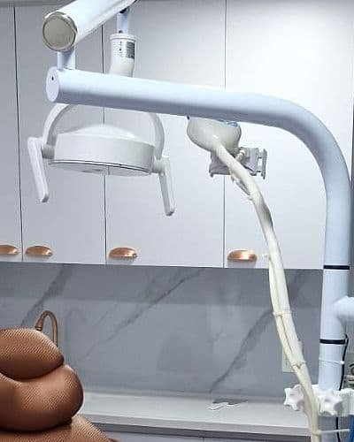 Lámpara blanca de la silla odontológica frente a los muebles con manijas de cobre